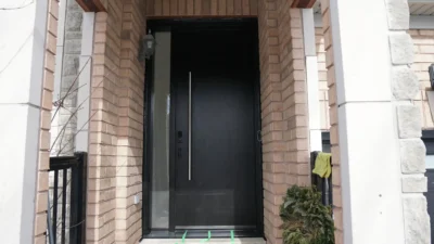 Modern dark mahogany fiberglass entry door with horizontal grooves and a multi-point lock system installed in Bradford.