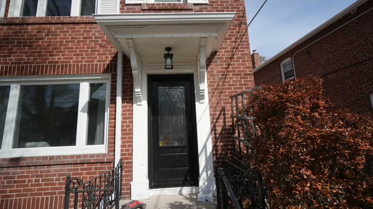 Secure and modern black fiberglass mahogany entry door with Champlain glass installed on a downtown townhouse.
