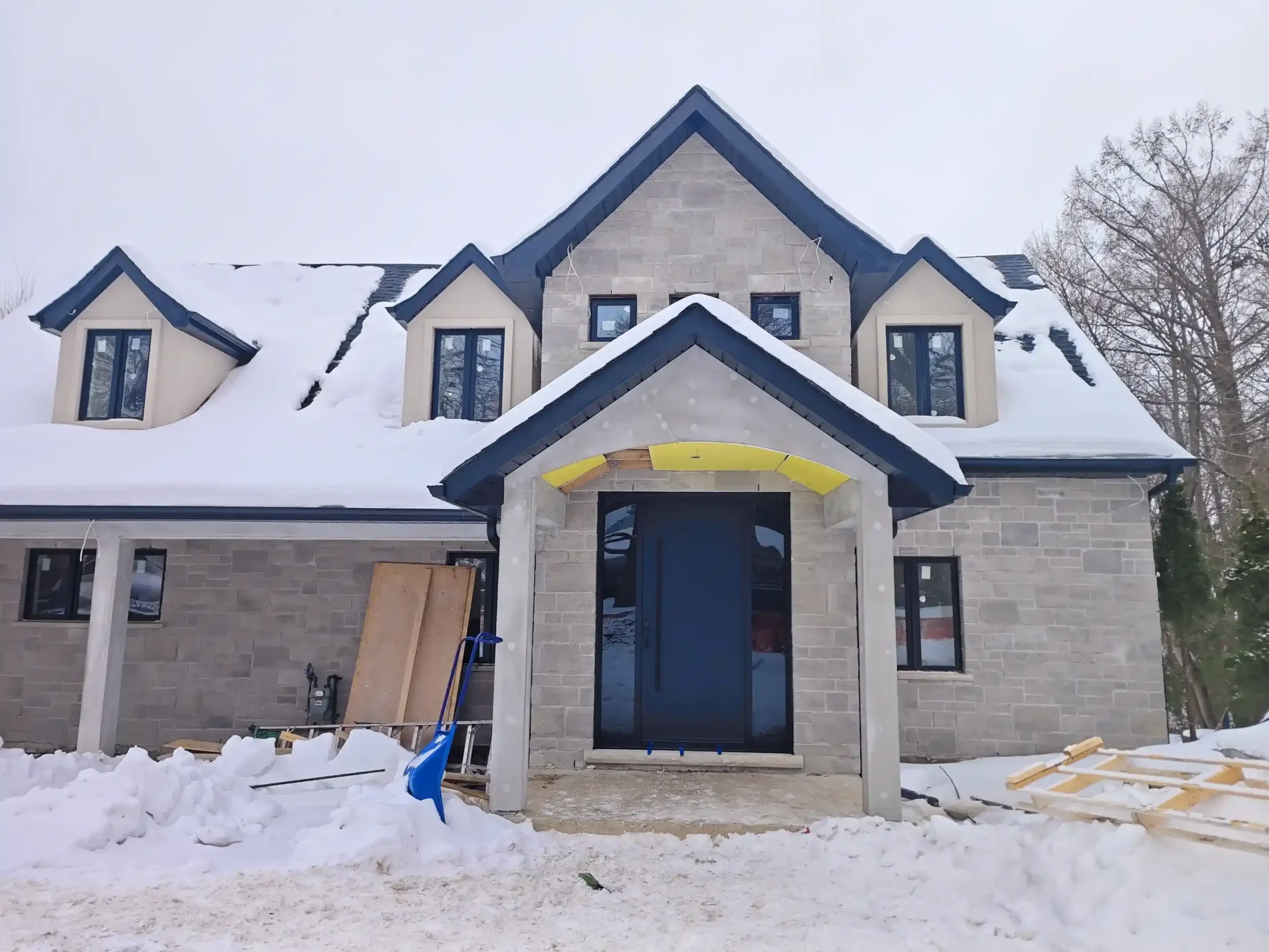 Modern dark mahogany fiberglass entry door with horizontal grooves installed by MapleFort on a snowy winter day in Newmarket.